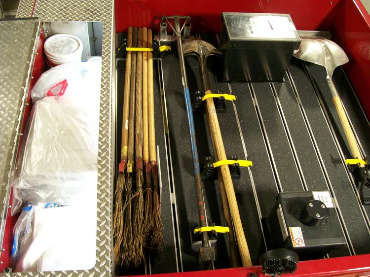 Open side compartment showing long tools and shelf storage channels