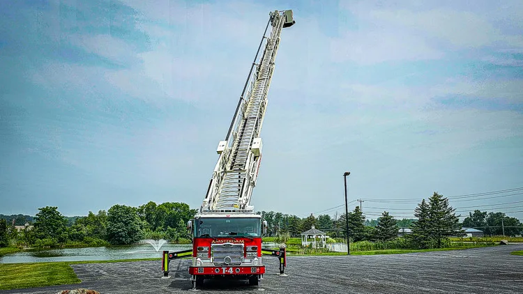 Front view of raised aerial ladder truck with ladder extended upward