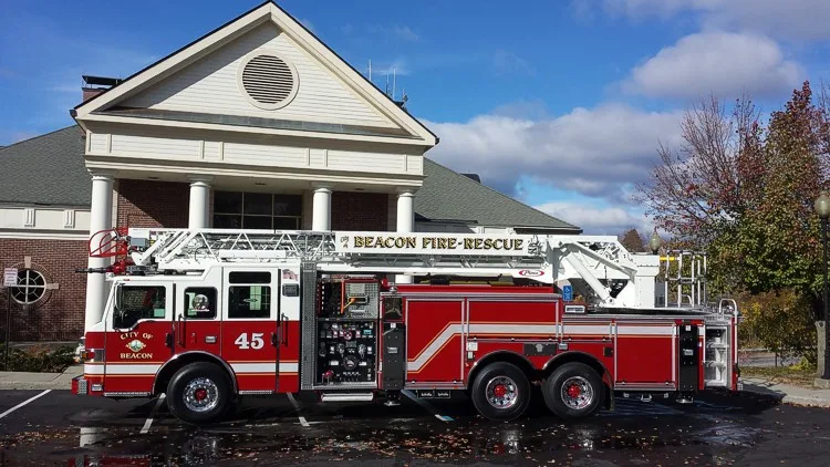 Full left-side profile showing pump panel controls, side compartments, and stowed aerial ladder.