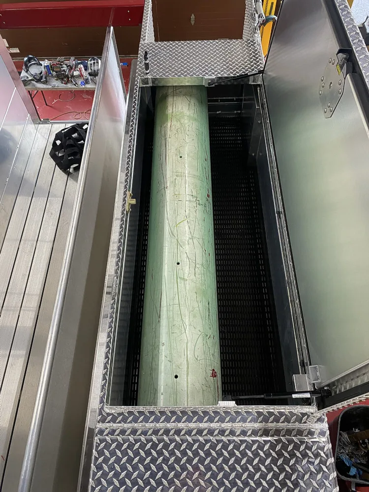 Open upper compartment showing cylindrical tube and divider rails in storage bay