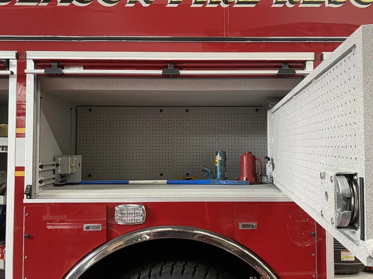 Open side compartment showing empty shelf bay with pegboard back panel
