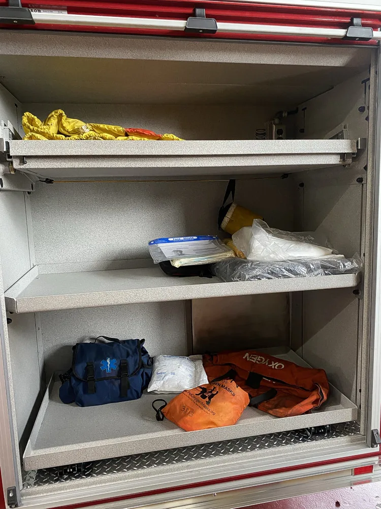 Open side compartment showing shelves with gloves and small equipment