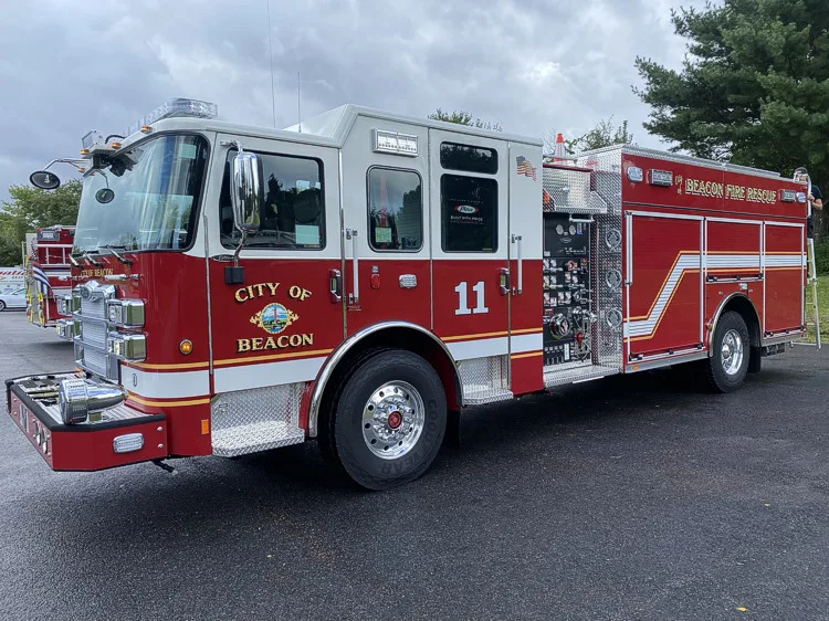Driver-side profile view showing pumper body and side panel striping