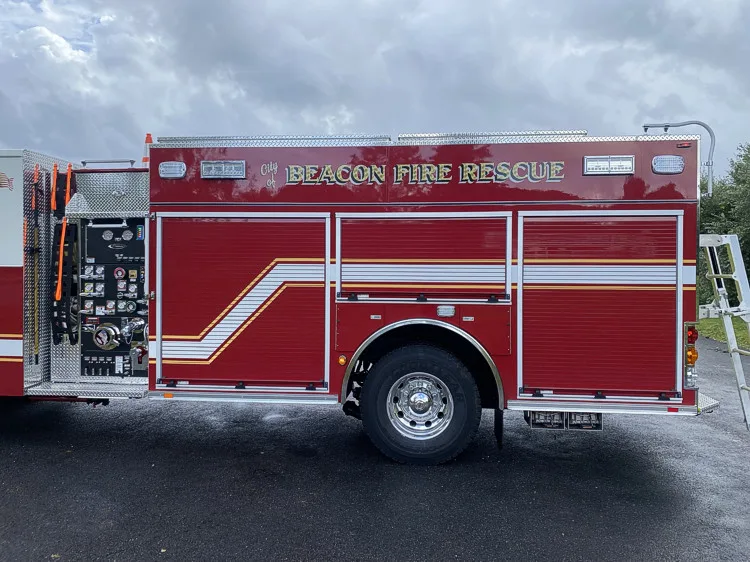 Driver-side full profile showing pumper body and side stripe layout