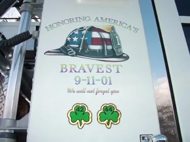 Bucket side panel close-up showing 9-11 tribute decal and shamrock emblems