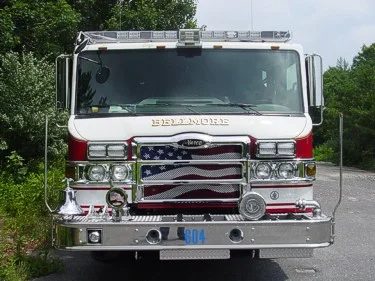 Head-on front view showing grille, warning lights, windshield, and front bumper intake ports.