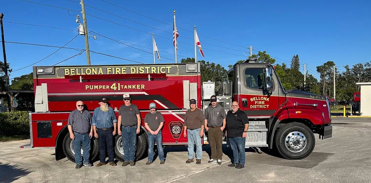 Group photo in front of tanker truck showing side profile and cab