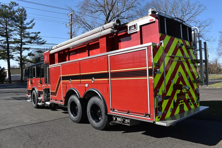 Rear-left exterior view showing tandem rear axles and rear chevrons