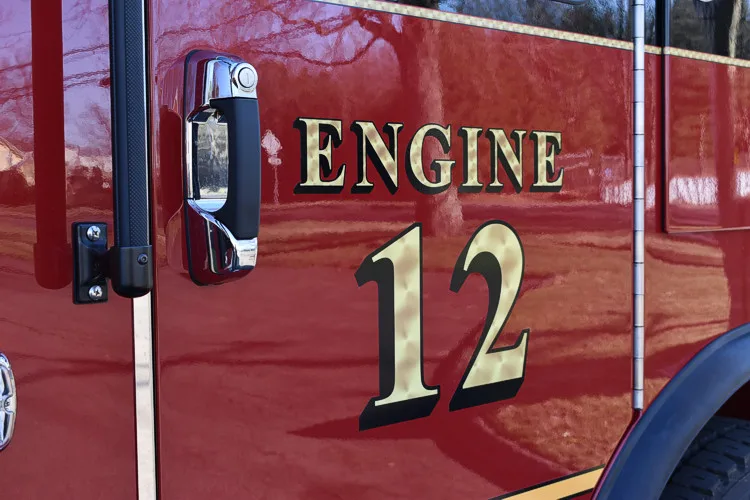 Body side close-up showing raised engine unit lettering on red paint