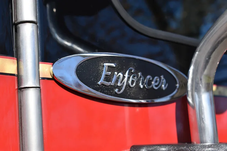 Body badge close-up showing Enforcer emblem on red panel