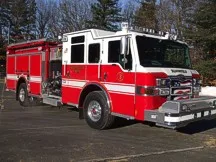 Wide front right view of the parked pumper showing bumper, cab, and full side body.