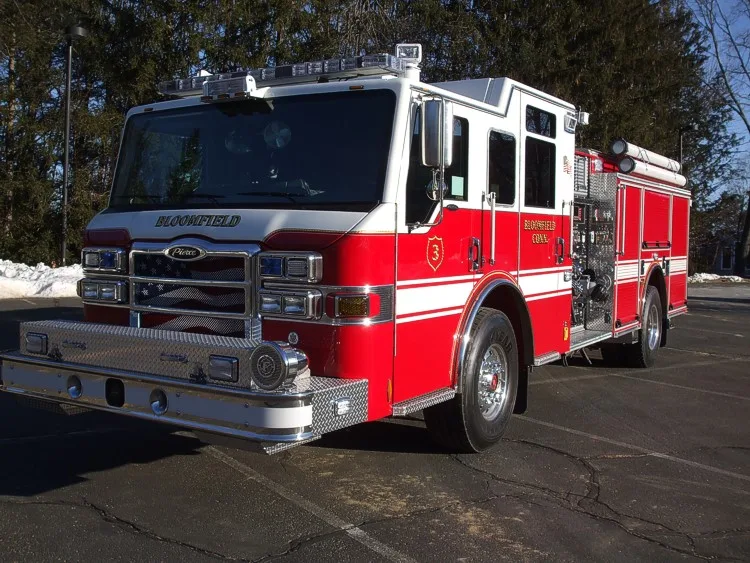 Front right angle highlighting the cab doors, chrome bumper, and pump panel section behind the cab.