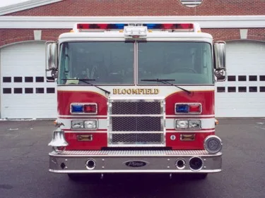 Head-on front view showing grille, warning lights, and bumper in front of station bays