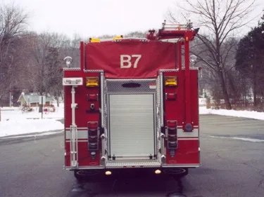 Rear view showing roll-up rear door, warning lights, and upper hosebed cover marked B7