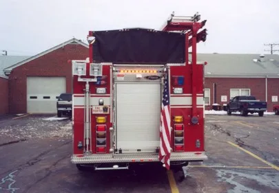 Rear view showing rear roll-up door, warning lights, and hosebed opening