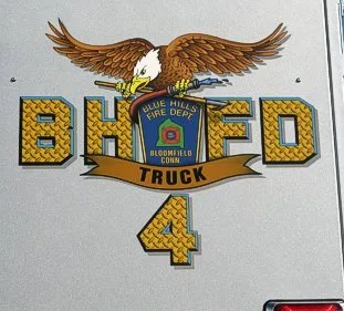 Close-up of a side logo panel with eagle artwork and unit number on the rear bucket section.