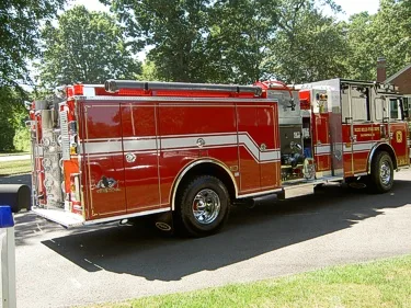 Rear-left exterior view showing side hosebed rails and rear wheel area