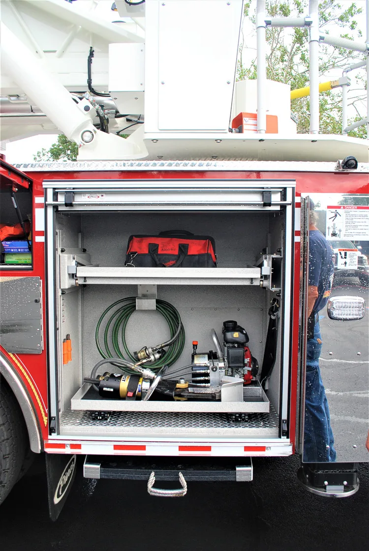 Open rear-side compartment showing hose reel and lower equipment shelf