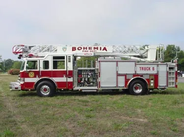 Driver-side full profile showing ladder bed, side compartments, and wheel area