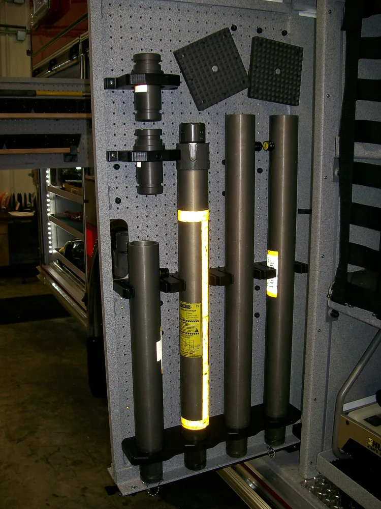 Open side compartment showing long tools and pike poles in rack