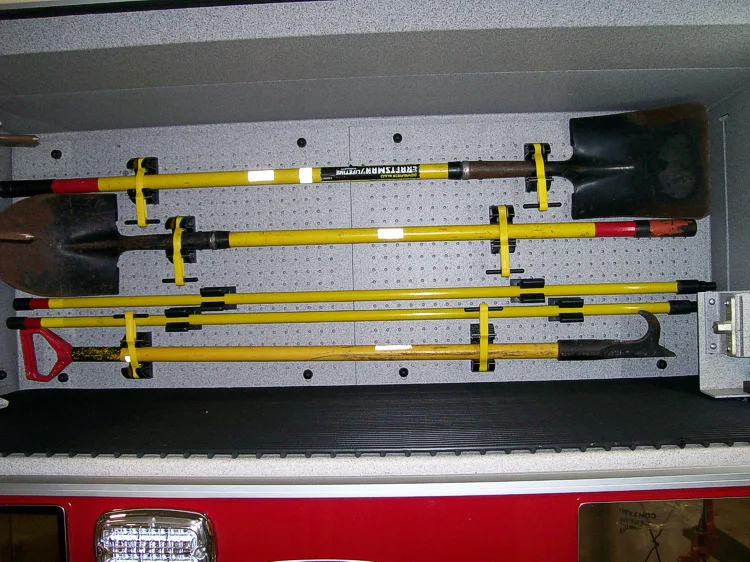 Open side compartment showing hand tools on yellow retaining clips