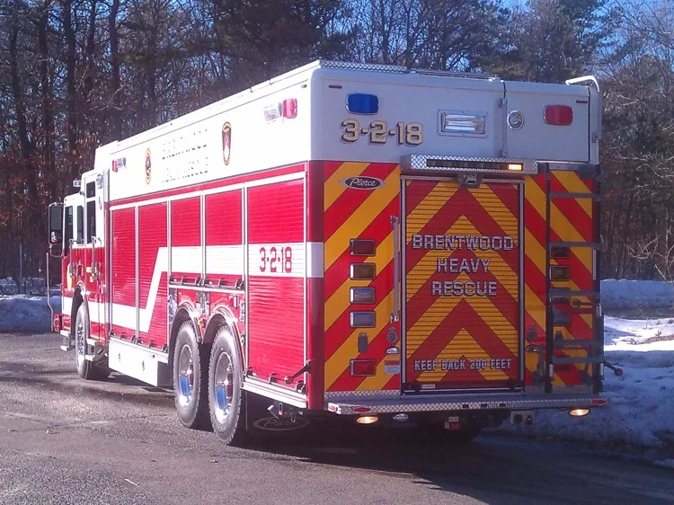 Rear right side view showing rear chevron door, side compartments, and tandem rear wheel area.