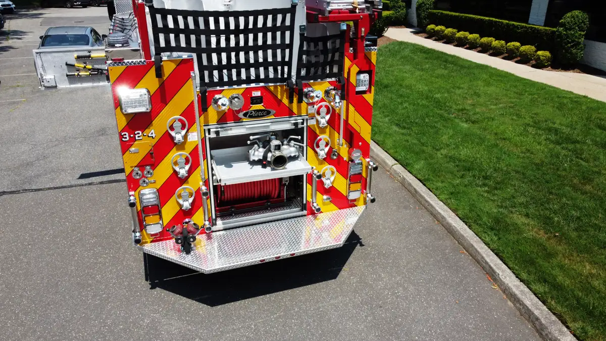 Pierce pumper aerial rear view showing chevron striping and rear hose connections