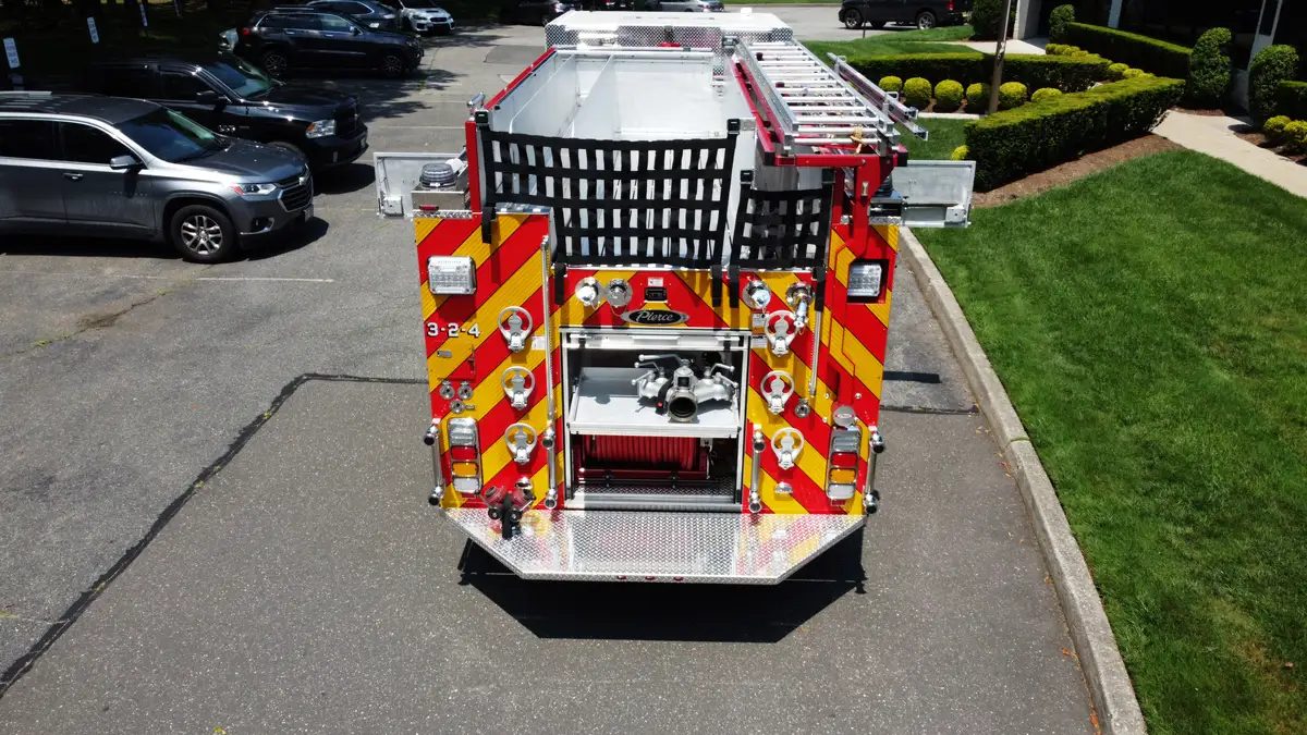 Pierce pumper aerial rear view with open rear compartment and ladder rack