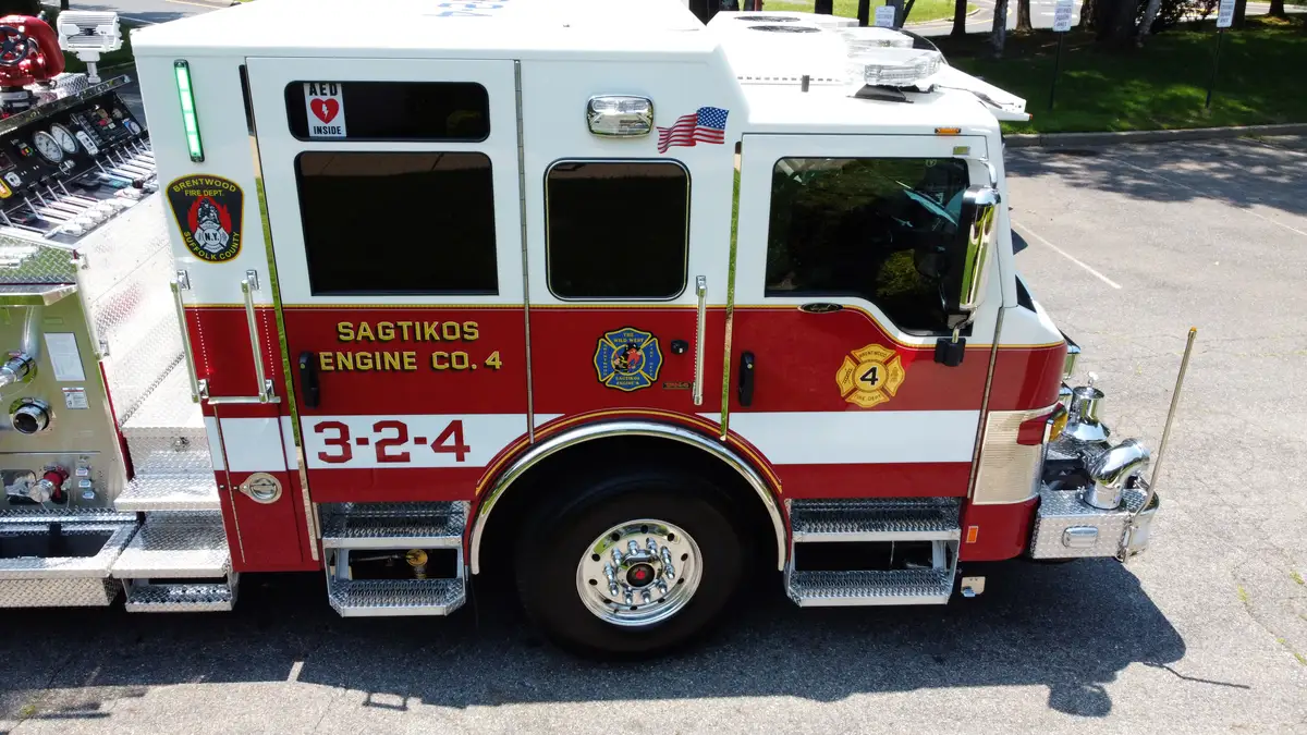 Pierce pumper aerial cab-side close-up showing front wheel and door area