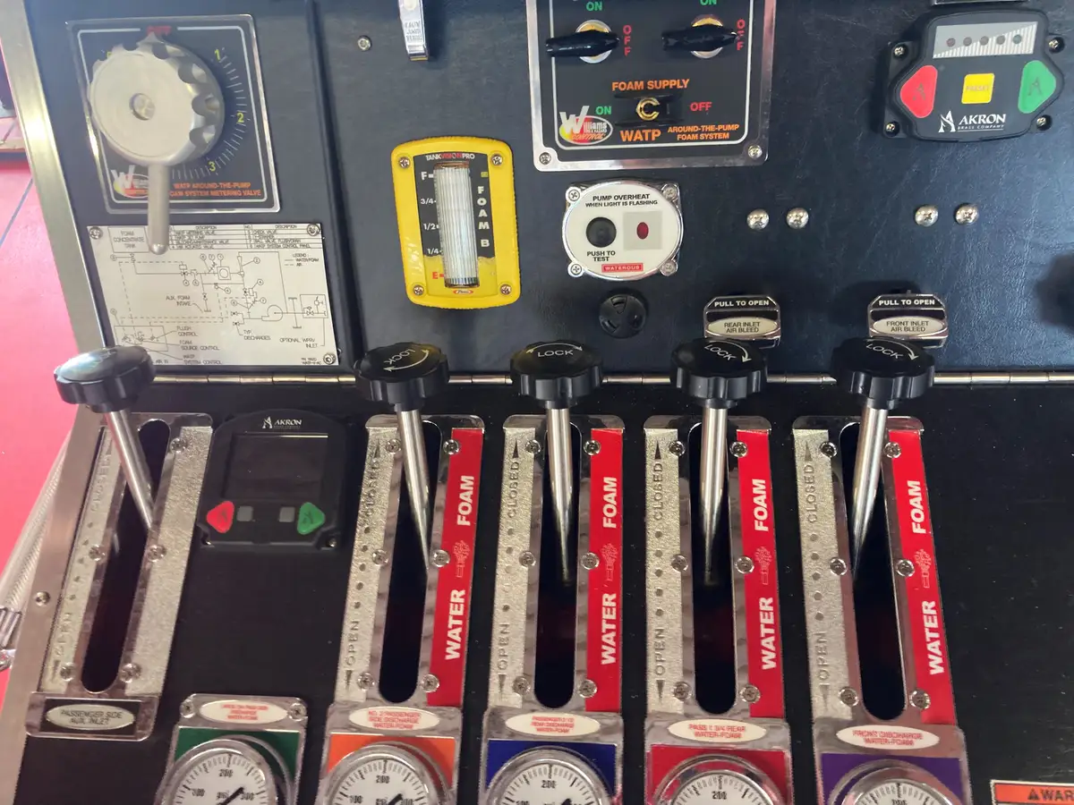 Pump panel controls close-up showing labeled discharge levers and pressure gauges