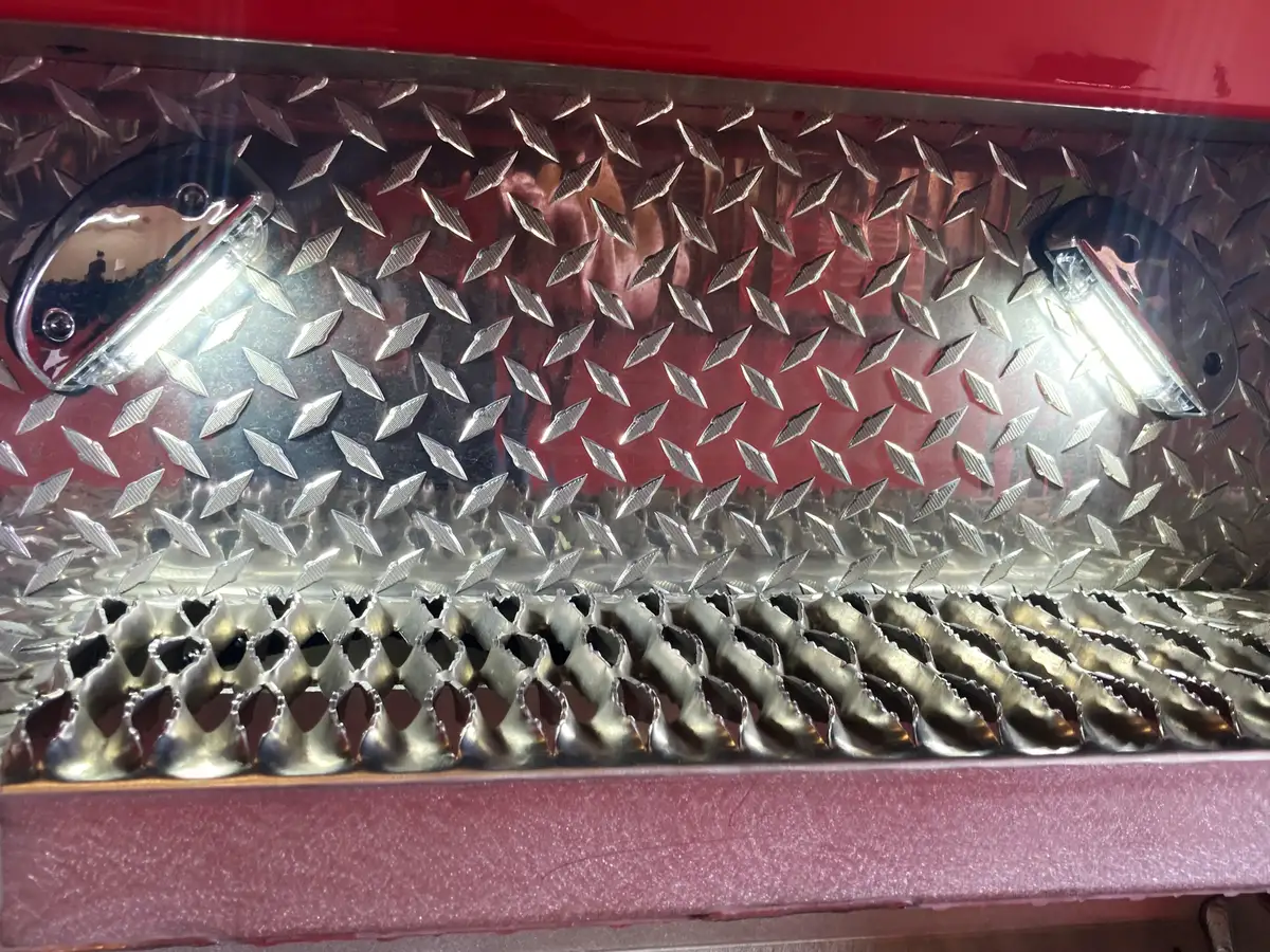 Open lower step compartment with perforated step and interior lighting