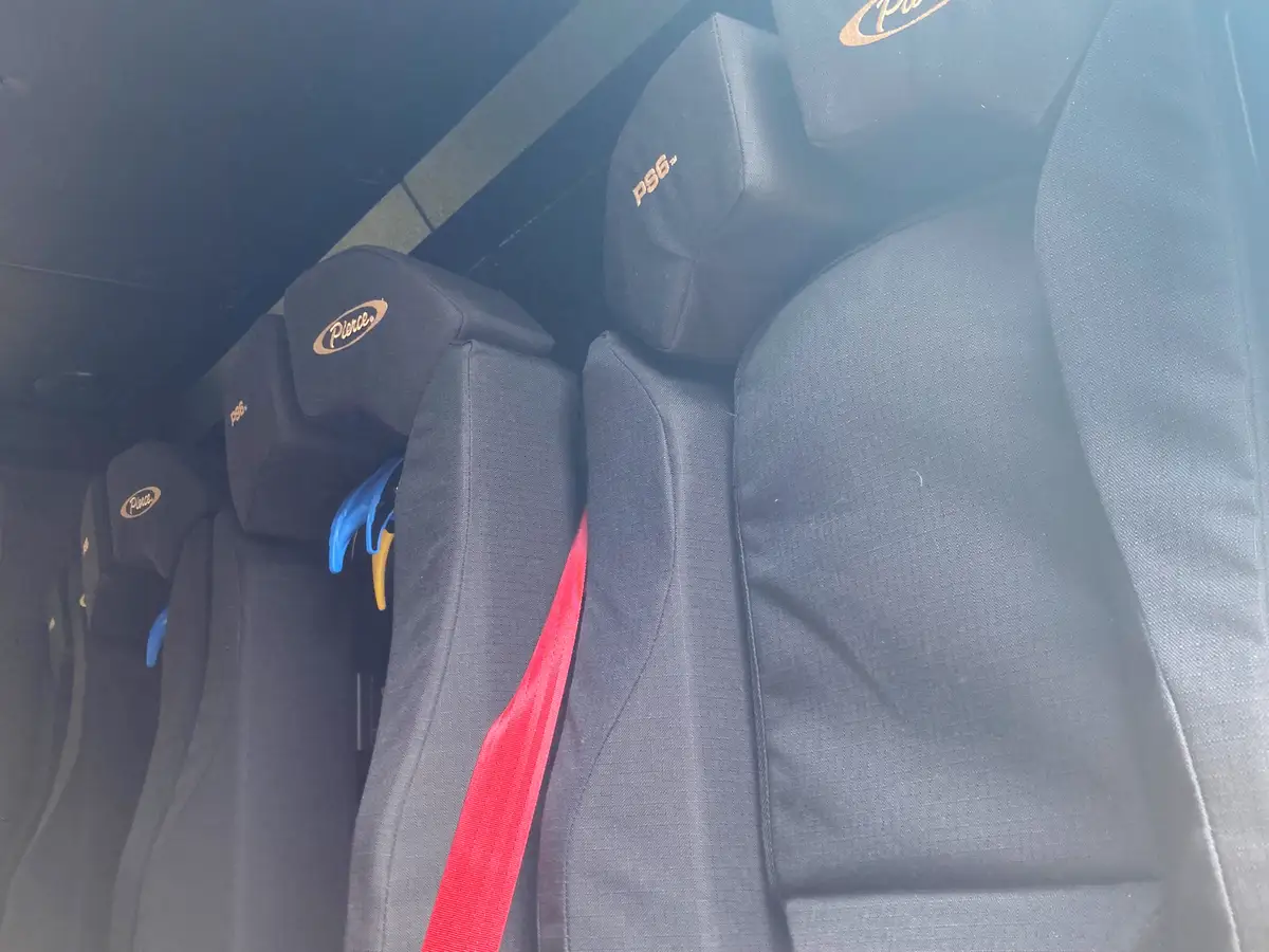 Rear crew seating close-up showing contoured seatbacks and safety restraints