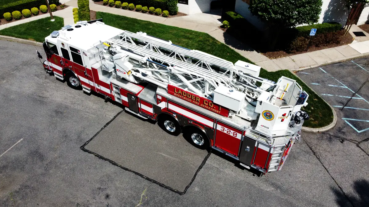 Pierce tower ladder elevated officer-side profile with aerial device nested above compartments