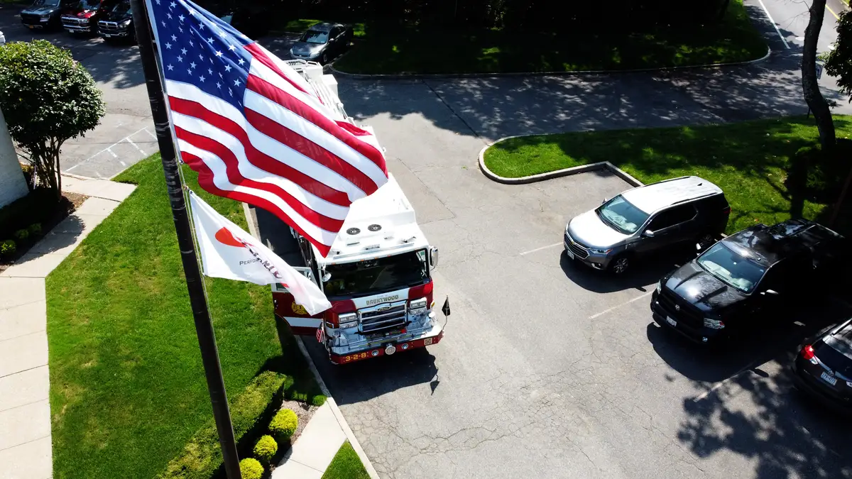Pierce tower ladder aerial front-quarter view with flagpole and full body visible