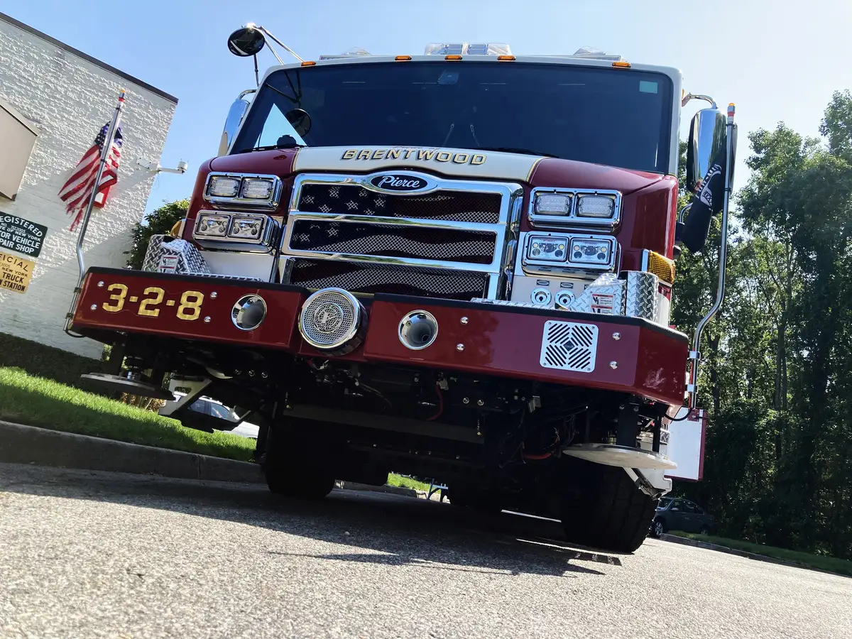 Two firefighters standing in front of the apparatus for delivery photo