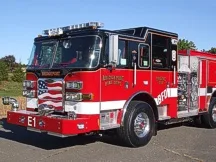 Front-left view showing open cab door, bumper, and side compartments