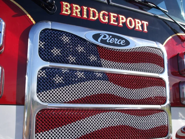 Grille close-up showing mesh pattern, emblem badge, and painted flag design