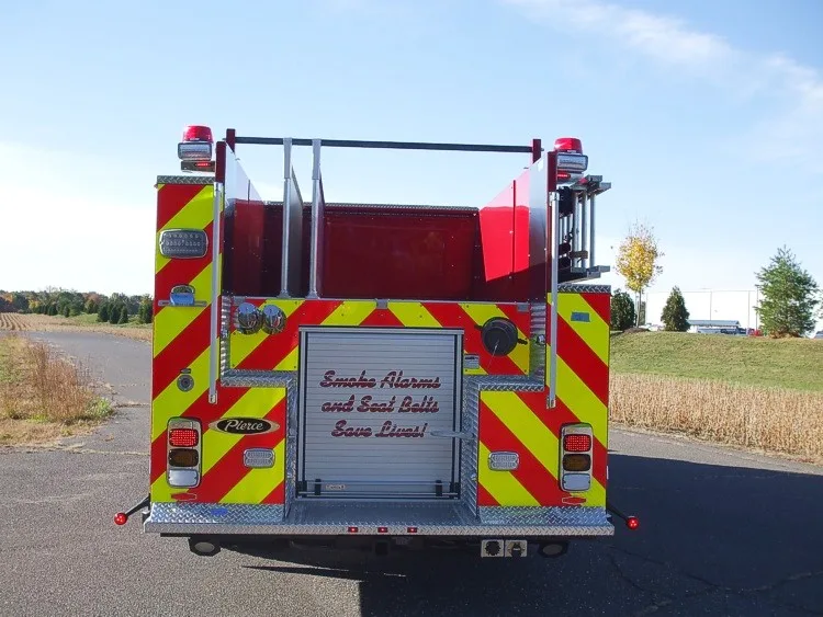 Rear view showing chevron striping, rear roll-up door, and hosebed opening