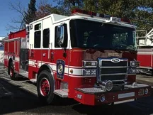 Wide front-right view of the pumper parked in the lot with full side body visible.