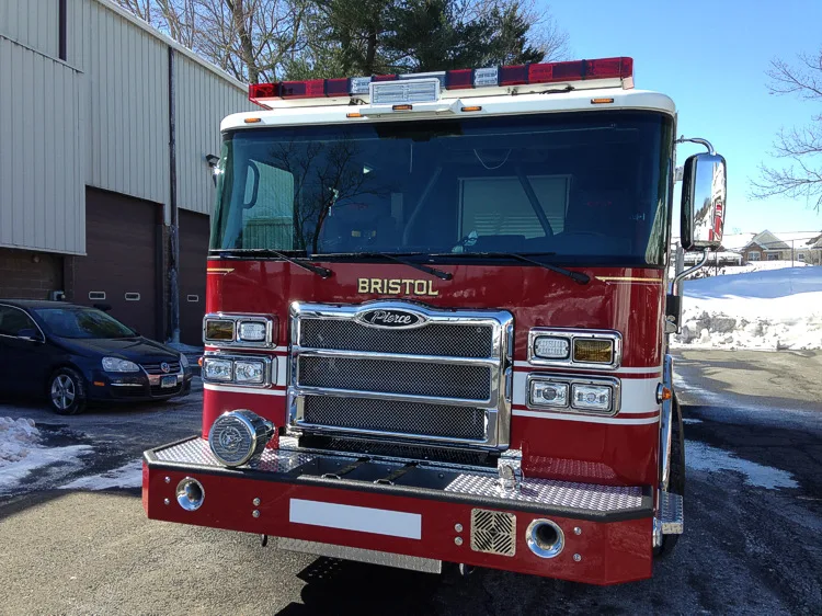 Head-on front view showing grille, windshield, warning lights, and bumper intake ports.