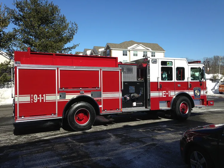 Driver-side profile showing the exposed pump panel, side compartments, and wheel/tire area.