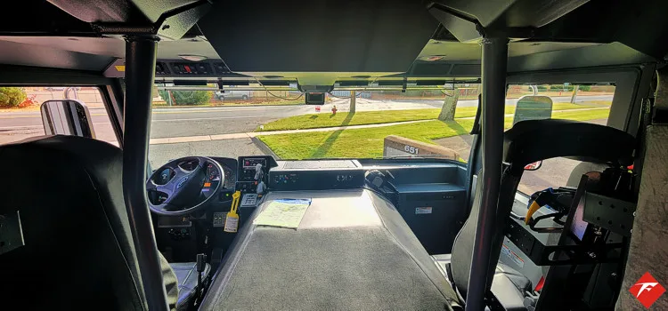 Cab interior side view showing center aisle, seats, and rear door opening