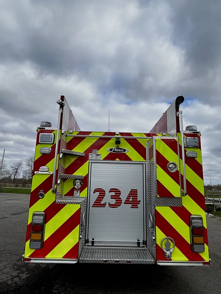 Rear view showing chevron striping, rear compartment door, and tail lights