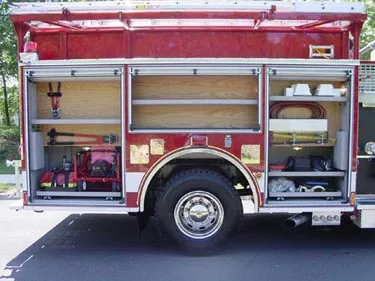 Passenger-side open compartments showing shelves, tools, and rear wheel area
