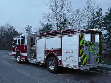 Rear-right exterior view showing side compartments and rear warning striping