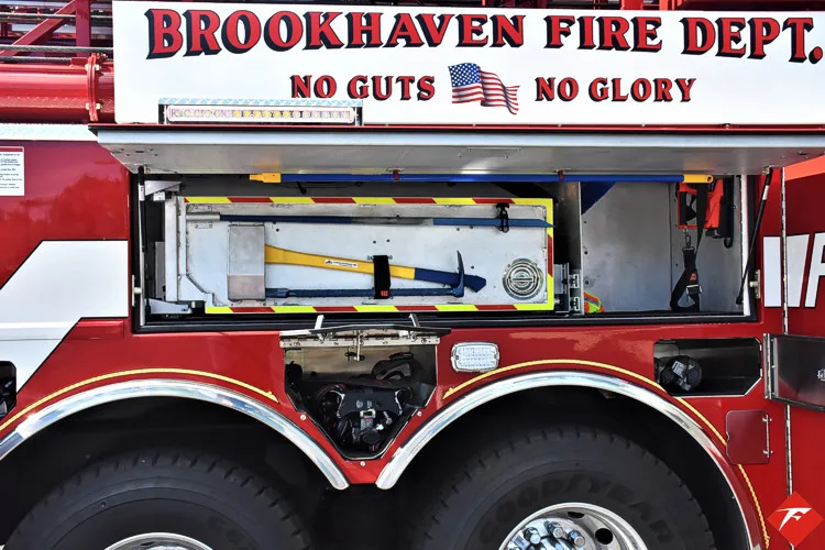 Open side compartment showing mounted hand tools above tandem rear wheels