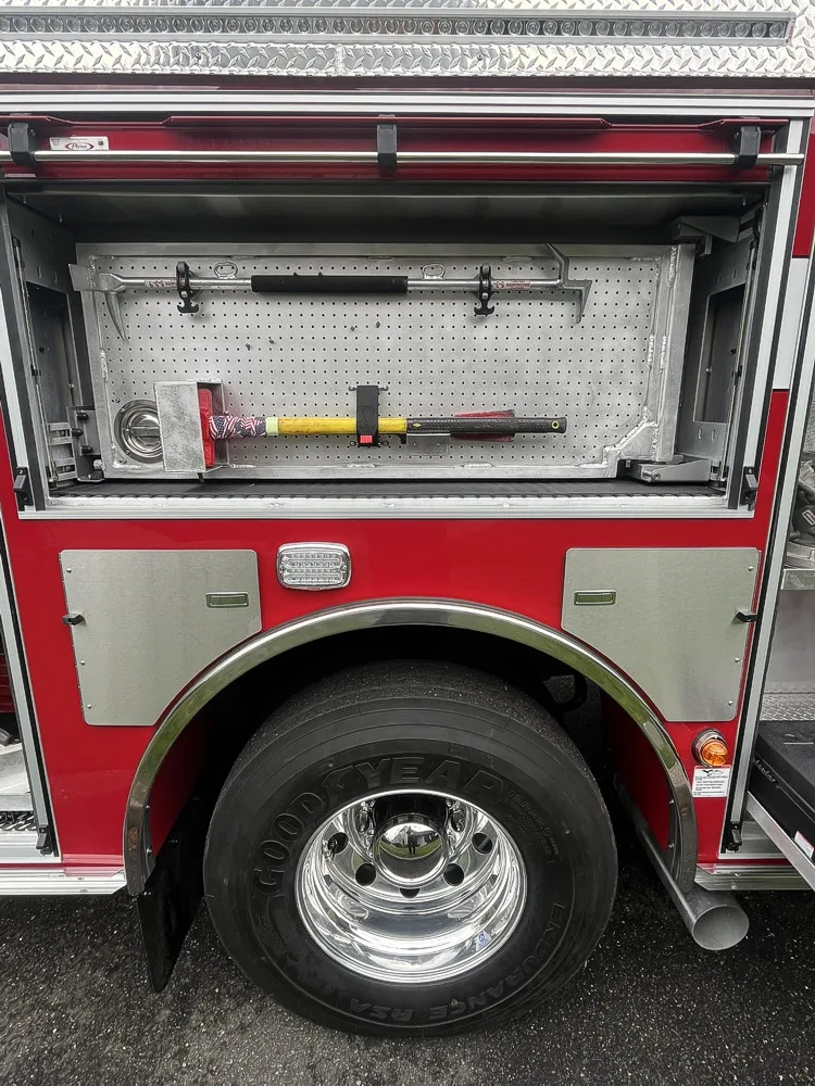 Open side compartment with hand tools, adapters, and storage cases on a slide-out tray