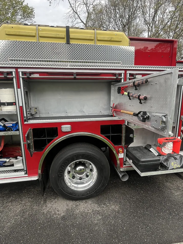 Open side compartments and wheel area showing mounted tools and rear tire