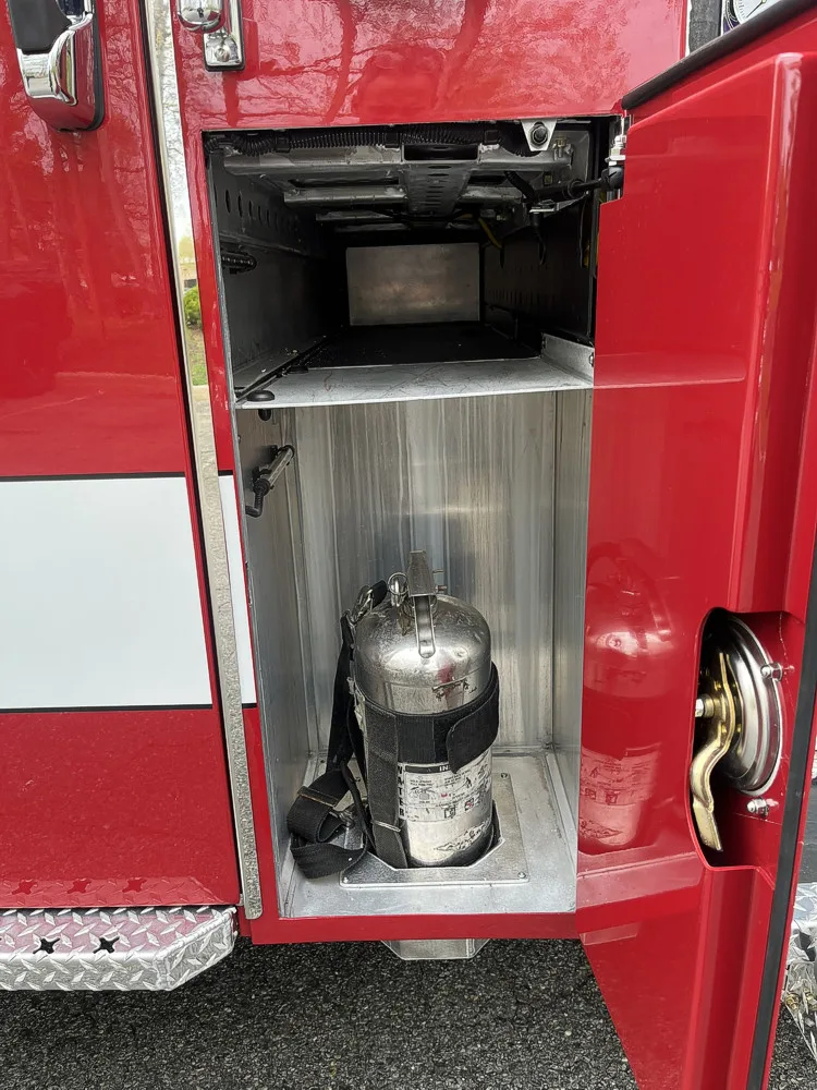 Narrow side compartment with mounted cylinder and under-cab storage