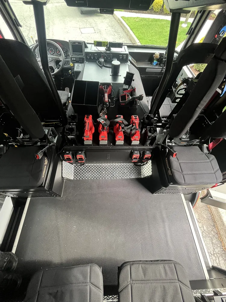 Cab interior view showing crew seats, command console, and mounted battery tools